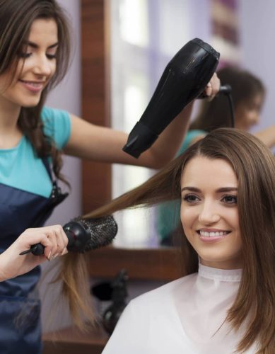 female-hairdresser-using-hairbrush-hair-dryer